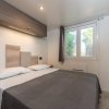 Interno di una camera da letto moderna con letto matrimoniale, finestra e scaffali.