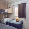 Camera con letto a castello e singolo, orsetto di peluche sulla coperta.