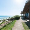 Struttura con veranda vista mare e sentiero costiero.