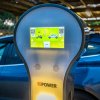 Stazione di ricarica per veicoli elettrici davanti a un'auto blu.