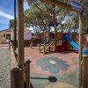 Parco giochi con scivolo e pavimento colorato.