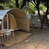 Tenda moderna con patio in legno, due sedie e un tavolo.
