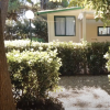 Un bungalow circondato da alberi e siepi.