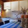 Cucina rustica con tavolo a quadri, tende colorate e candele su supporti.