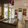 Cucina moderna con tavolo da pranzo, vista su due camere da letto.