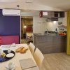 Tavolo da pranzo apparecchiato, cucina moderna a vista.