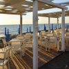 Sedie e tavoli su un patio in riva al mare al tramonto.