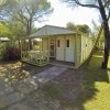 Bungalow con veranda in un'area alberata.
