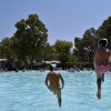 Due persone entrano in una piscina all'aperto.