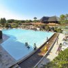 Una grande piscina con persone e sedie a sdraio.
