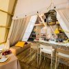 Interno di una tenda glamping con cucina e tavolo apparecchiato.