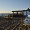 Spiaggia sabbiosa con pedalò, mare al tramonto e struttura 