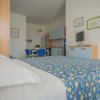 Camera da letto con copriletto floreale blu e mobili chiari.