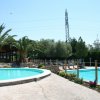 Due piscine all'aperto circondate da palme e sedie a sdraio.