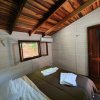 Camera da letto con letto matrimoniale e finestra, pareti in legno.