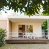 Veranda con sedie bianche davanti a una casa moderna.
