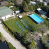 Veduta aerea di un campo con piscina e lettini.