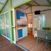 Veranda con cucina blu, tavolo e sedie.